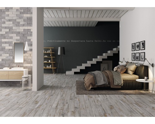 Ljust rum med trägolv, säng, trappa och tvättställ