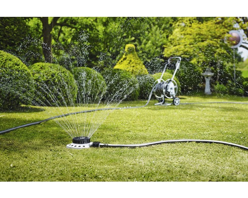 Grässpridare vattnar gräsmattan i trädgården