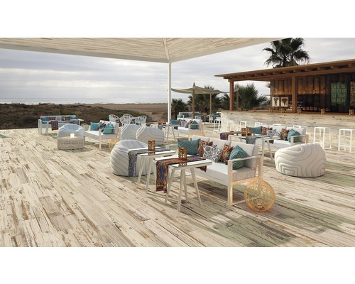 Uteplats med terrassplankor, loungemöbler och bar