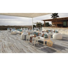 Uteplats med trägolv, sittmöbler och bar vid stranden