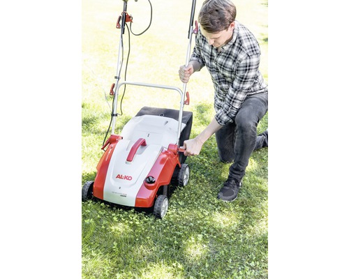 Man använder en gräsmattluftare av märket AL-KO i trädgården.