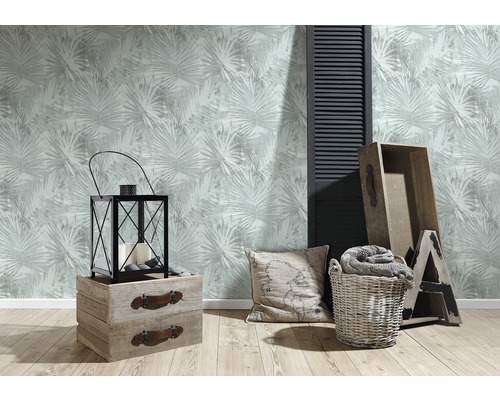 Vardagsrum med mönstrad tapet, lykta, trälådor, kudde och tvättkorg för en mysig atmosfär