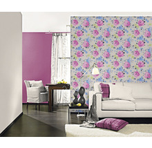 Vardagsrum med blommig tapet, soffa och fåtölj