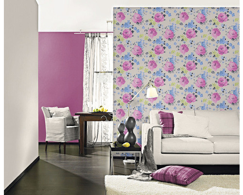 Vardagsrum med blommig tapet, soffa och fåtölj