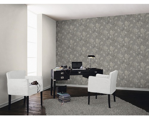Vardagsrum med skrivbord, fåtöljer och blommig tapet