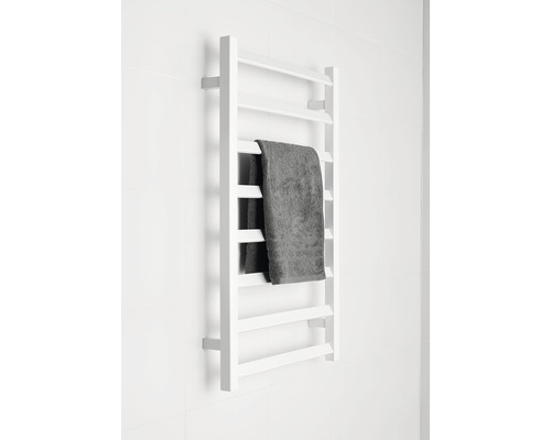 Vit handdukstork med handduk monterad på väggen