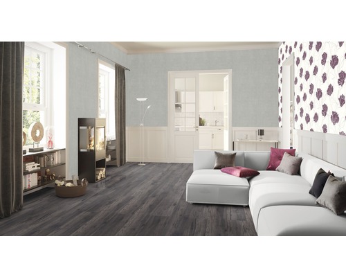 Vardagsrum med soffa, kamin, bokhylla och laminatgolv.