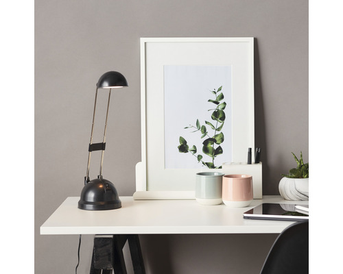 Skrivbord med lampa, inramad bild, muggar och surfplatta