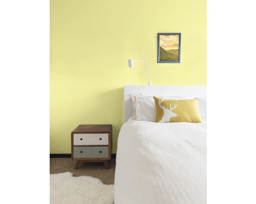 Sovrum med säng, sängbord och väggdekoration för en mysig atmosfär.