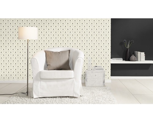 Ljust vardagsrum med mönstrad tapet, fåtölj och golvlampa