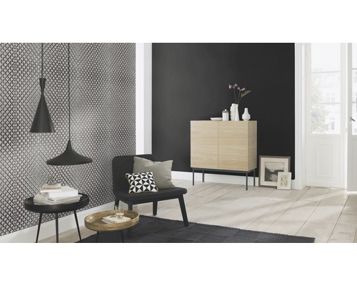 Vardagsrum med mönstrad tapet, träskåp och mörkt läshörna