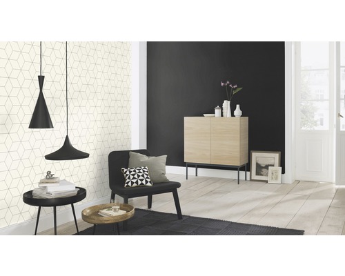 Ljust vardagsrum med mönstrad tapet, skåp, fåtölj, matta och pendellampor