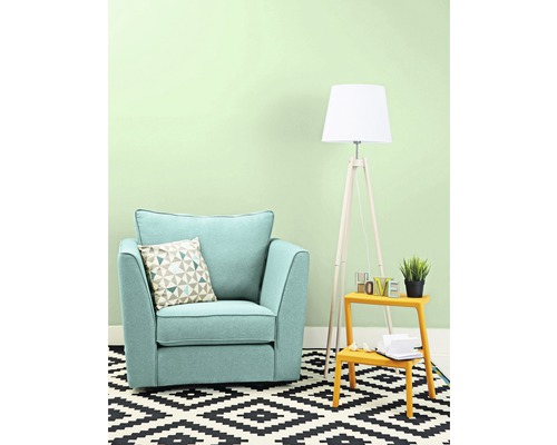 Vardagsrum med fåtölj, kudde, golvlampa och matta med geometriskt mönster