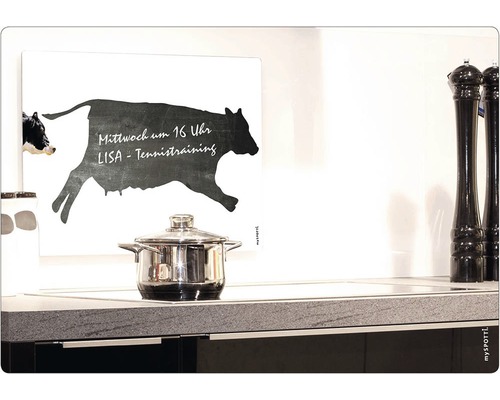 Kök med kastrull, kryddkvarnar och väggmålning med ko-motiv