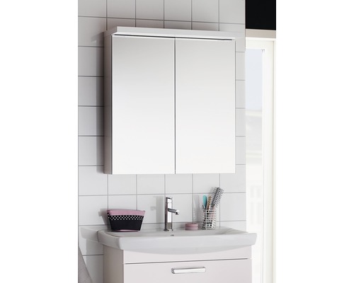 Badrum med spegelskåp ovanför ett handfat.