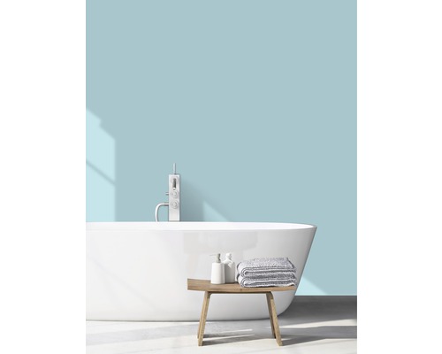 Ljust badrum med fristående badkar, blandare, handdukar och träbänk