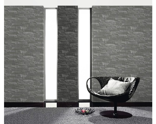 Vardagsrum med tapet i stenlook och fåtölj