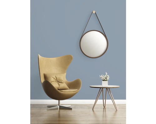 Vardagsrum med fåtölj, sidobord, spegel och dekoration