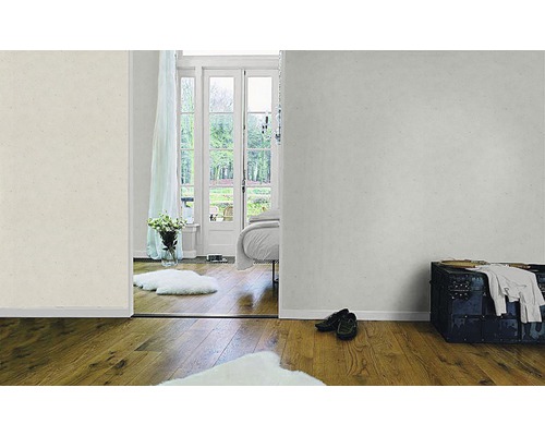 Ljust rum med diskret mönstrad tapet, trägolv och utsikt över trädgården.