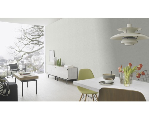 Ljust vardagsrum med matbord, stolar, skänk och stort fönster