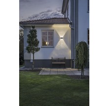 Utomhusvy av ett hus med trädgård och upplyst fasad