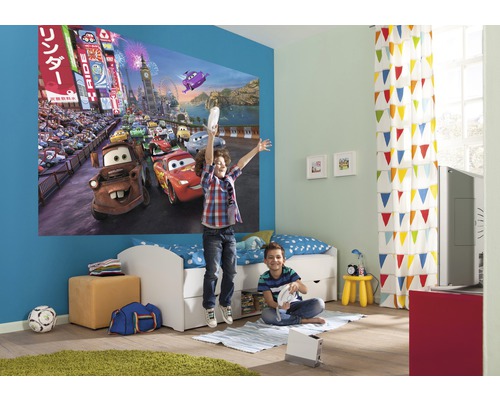 Barnrum med väggmålning racingbana, säng och lekande barn