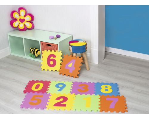 Lekrum med hyllor, pall och färgglada skumgummimattor med siffermotiv.