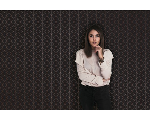 Kvinna framför en geometrisk tapet