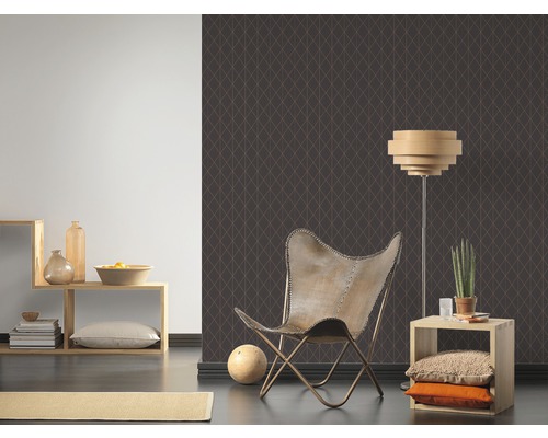 Vardagsrum med mönstrad tapet, fåtölj och lampa