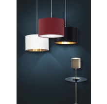 Tre textilupphängda lampor med olika lampskärmsfärger och en bordslampa på ett sidobord.