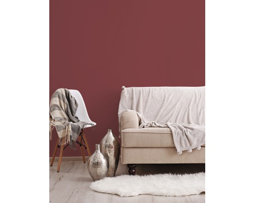 Vardagsrumsscen med soffa, stol, matta och dekoration mot en vägg