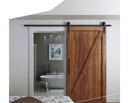 Skjutdörr i trä framför ett badrum med badkar och ljuskrona