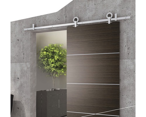 Skjutdörr i trä med beslag på betongvägg