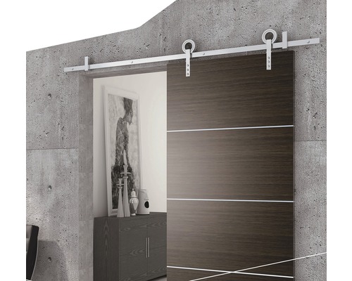 Skjutdörr med stålyta och monteringssats framför en betongvägg