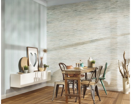 Matsal med träbord och stolar framför en vägg med mönster och en vägg med ränder