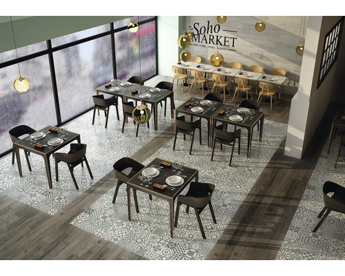 Restauranginteriör med bord, stolar och dekorativa golvplattor.