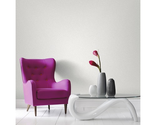 Rum med fåtölj, bord och tapeter på väggen