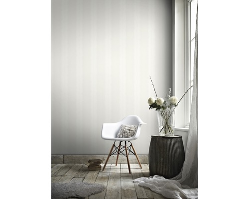 Vardagsrum med randig tapet, stol, sidobord och blomvas