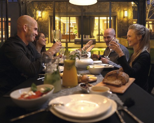 En grupp människor sitter vid ett dukat bord under en middag