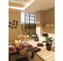 Rum inredd i asiatisk stil med bord, sittkuddar och Buddha-staty.