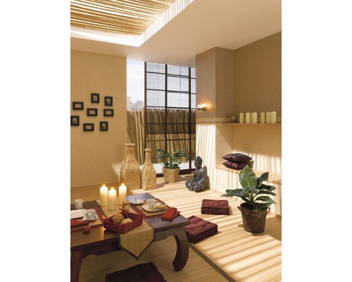 Rum inredd i asiatisk stil med bord, sittkuddar och Buddha-staty.