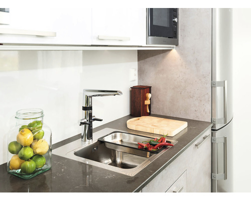 Köksscen med diskho, kran, skärbräda, kryddor och en skål med citroner och limefrukter.