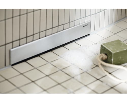 Golvbrunn med Geberit-logotyp i badrummet.