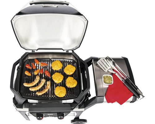 Öppen grill med korv, hamburgare och grönsaker.