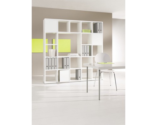 Vit hylla med fack för förvaring av pärmar och böcker på ett kontor.