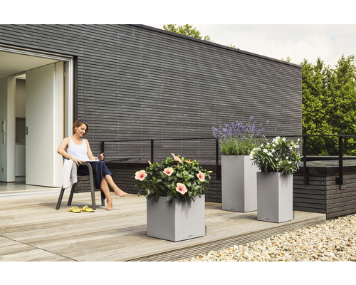 Terrass med blomlådor och avslappnande kvinna