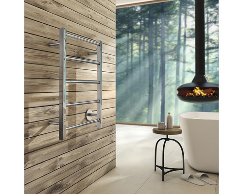 Modernt badrum med metalluppvärmd handdukstork på en trävägg