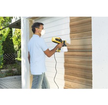 Man lackerar trävägg med färgspraysystem
