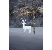 Belyst dekoration med renfigur och träd i snöig utomhusmiljö