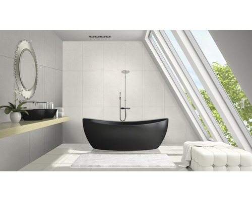 Modernt badrum med fristående badkar, tvättställ och takfönster för dagsljus